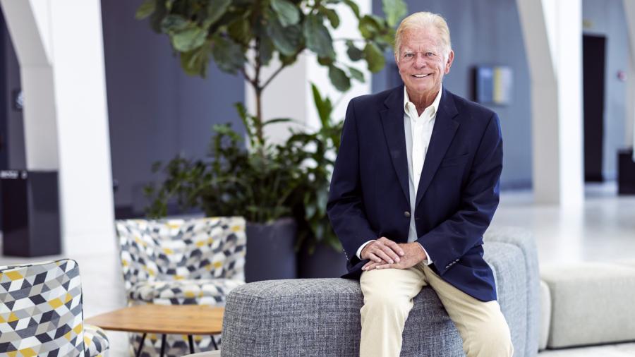 Warner Croft sits in the Hurd Welcome Center on Baylor campus, dressed in a sport coat and khakis, smiling for a portrait